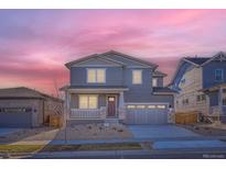 Charming two-story home featuring a covered porch, gray siding, stone accents and a two car garage at 2690 E 102Nd Pl, Thornton, CO 80229