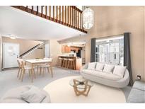 Bright living room featuring hardwood floors, vaulted ceilings, modern furnishings, and a view into the kitchen at 2141 S Victor St # B, Aurora, CO 80014