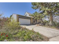 Charming home with a two-car garage, front yard flowers, and beautiful mature trees in a peaceful neighborhood at 14742 E Radcliff Pl, Aurora, CO 80015