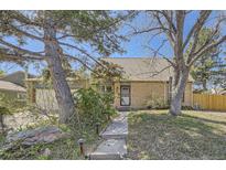 Charming brick home featuring a well-manicured lawn and mature trees enhancing its curb appeal at 14742 E Radcliff Pl, Aurora, CO 80015