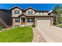 Beautiful two-story home with stone accents, a well-manicured lawn, and an attached two-car garage at 15647 Weaver Gulch Dr, Morrison, CO 80465
