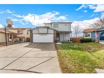 Two-story house with attached garage and landscaped lawn at 6119 Zenobia Ct, Arvada, CO 80003