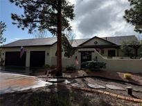 Charming stucco home features a gated courtyard, lush landscaping, and a convenient two-car garage at 17995 Minglewood Trl, Monument, CO 80132