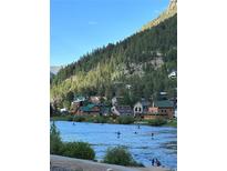 Beautiful community view with paddle boarders on the river and homes nestled against a green hillside at 1890 Argentine St # D203, Georgetown, CO 80444