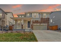 Inviting two-story home with a stone facade, covered porch, and well-maintained lawn at 236 Back Nine Dr, Castle Pines, CO 80108