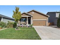 Inviting home featuring a well-manicured lawn and a charming front porch with seating at 1772 Taos St, Brighton, CO 80603