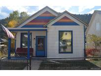 Charming two-story home with colorful roof tiles, blue trim and inviting front porch at 215 Colorado Blvd, Idaho Springs, CO 80452