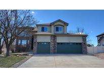 Charming two-story home with a large driveway and green garage doors at 8024 W 95Th Way, Broomfield, CO 80021