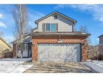 Two-story home with a brick front and a two-car garage, offering curb appeal and convenient parking at 14558 Vine St, Thornton, CO 80602