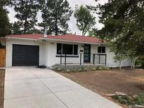 Charming exterior featuring a painted brick facade, modern black accents, and a well-maintained front yard at 3338 W Arlington Ave, Littleton, CO 80123
