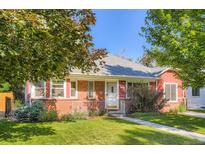 Charming brick home featuring a well-maintained lawn and walkway leading to the entrance at 1273 S Jackson St, Denver, CO 80210