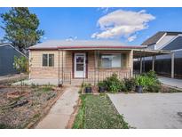 Charming home with a well-maintained front yard, walkway, and covered porch with a metal awning and decorative posts at 1910 S King St, Denver, CO 80219