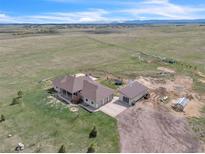 Expansive property featuring lush green pastures, mountain views, a detached garage, and a greenhouse at 15125 Spring Valley Rd, Larkspur, CO 80118