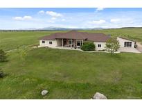 Sprawling ranch-style home with stone accents, attached garage, and picturesque mountain views at 15125 Spring Valley Rd, Larkspur, CO 80118