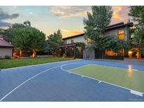 Backyard basketball court provides great outdoor entertainment space next to the house and mature landscaping at 235 Eudora St, Denver, CO 80220