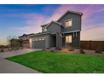 Beautiful two-story home featuring well-manicured lawn and a gray exterior paint scheme at dusk at 6954 E 117Th Ave, Thornton, CO 80233