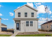 Charming two-story home with white siding, well-maintained landscaping and inviting front porch at 2974 Oxley St, Strasburg, CO 80136