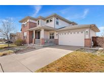 Charming two-story home with a brick facade and a two-car garage and covered front porch at 4464 E 139Th Ave, Thornton, CO 80602