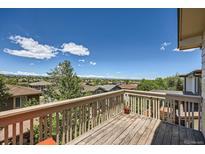 Inviting back deck boasts wooden railings and panoramic views of the neighborhood and mountains beyond at 10528 Applebrook Cir, Highlands Ranch, CO 80130