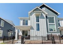 Charming two-story home with light gray and dark blue accents, modern windows, and a black metal fence at 1998 S Poplar Ct, Denver, CO 80224