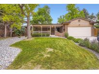 Charming brick home with a manicured lawn and covered front porch in a well-landscaped yard at 1048 N Columbine St, Golden, CO 80403