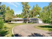 Charming ranch-style home with lush landscaping and a circular driveway at 8813 Baseline Rd, Lafayette, CO 80026