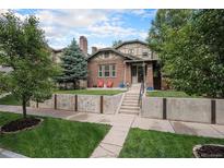 Charming brick two-story home with a well-manicured lawn and a concrete retaining wall at 726 S Corona St, Denver, CO 80209