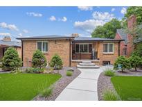 Charming brick home with manicured front yard featuring lush greenery, a welcoming walkway, and beautiful landscaping at 2664 Forest St, Denver, CO 80207