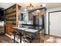 Charming kitchen featuring a black refrigerator, cabinets, countertops, and bar stool seating at 2700 S Holly St # 202, Denver, CO 80222