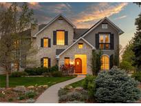 Charming two-story home with stone facade, black shutters, and landscaped front yard at 295 Jersey St, Denver, CO 80220