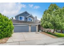 Charming two-story home features a two car garage and a well-manicured front yard with mature trees at 8927 Green Meadows Ln, Highlands Ranch, CO 80126