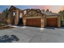 Beautiful home with stone accents and a large driveway leading to the three-car garage at 9009 Rambling Oak Pl, Parker, CO 80134