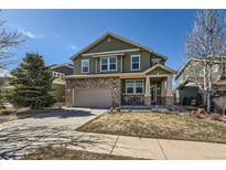 Charming two-story home with a stone facade, inviting front porch, and well-maintained lawn at 25332 E Indore Dr, Aurora, CO 80016