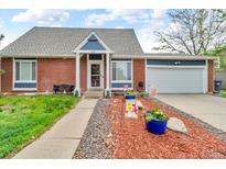 Charming brick home with well-manicured lawn, walkway and two car garage at 4694 S Ouray Way, Aurora, CO 80015