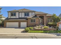 Charming two-story brick home with a well-manicured front yard and a two-car garage at 16261 W Ellsworth Ave, Golden, CO 80401