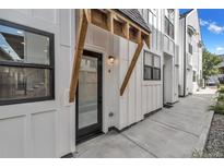 Modern townhome with a stylish wood accent over the front door and a well-maintained concrete walkway at 3219 W 19Th Ave # 4, Denver, CO 80204