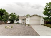 Charming single-story home featuring a neutral color palette, gravel front yard, and attached two-car garage at 11762 W 34Th Ave, Wheat Ridge, CO 80033
