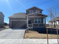 Charming two-story home with a covered porch and two-car garage at 16562 E 109Th Ave, Commerce City, CO 80022