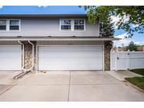 Attached two-car garage with white door and stone accents at 2813 S Xanadu Way, Aurora, CO 80014