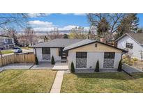 Charming single-story home featuring a well-manicured front lawn, xeriscaping, and a modern facade at 6711 Field St, Arvada, CO 80004