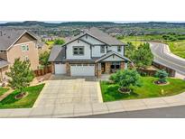 Beautiful two-story home featuring a manicured lawn, a three-car garage and mountain views at 2314 Fairway Wood Cir, Castle Rock, CO 80109