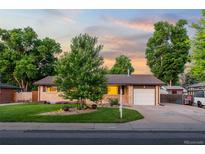 Charming brick ranch-style home with mature trees and landscaped front yard at 6114 Miller St, Arvada, CO 80004