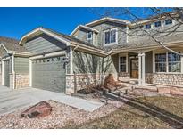 Exterior front view of home shows the stone accents, two-car garage, and walkway to the front door at 3938 Lazy K Dr, Castle Rock, CO 80104
