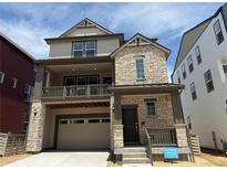 Charming two-story home featuring a stone facade, balcony, and attached two-car garage at 7307 Waterleaf Trl, Littleton, CO 80125