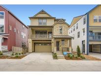 Two-story home with stone and wood accents, a front porch, and an attached two-car garage at 7307 Waterleaf Trl, Littleton, CO 80125