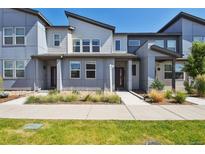 Modern townhome showcasing a contemporary architectural style, neat landscaping, and a welcoming walkway at 19221 E 65Th Ave, Denver, CO 80249