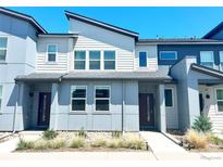 Modern two-story townhome with sleek architectural details and beautiful gray and white color scheme at 19221 E 65Th Ave, Denver, CO 80249