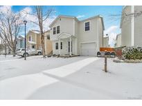 Charming two-story home with a one-car garage, front yard, and snowy driveway at 11848 W Tufts Pl, Morrison, CO 80465