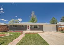 Charming brick home featuring a lush lawn, stone walkway, and attached two-car garage at 8361 Mason Cir, Westminster, CO 80031