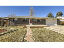 Charming brick home with a well-maintained front yard, stone pathway and a red front door, offering great curb appeal at 8361 Mason Cir, Westminster, CO 80031